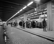 858388 Afbeelding van vergeefs wachtende reizigers op het autobusstation op het Stationsplein te Utrecht, tijdens een ...